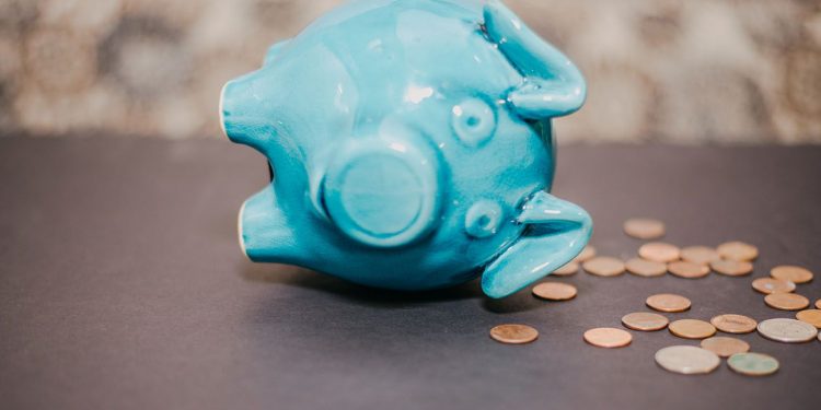 Blue piggy bank falling over