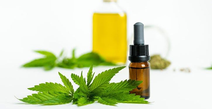 CBD oil next to a cannabis leaf