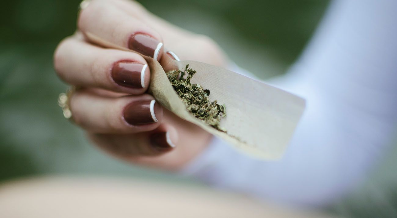 Australian woman rolling a cannabis joint