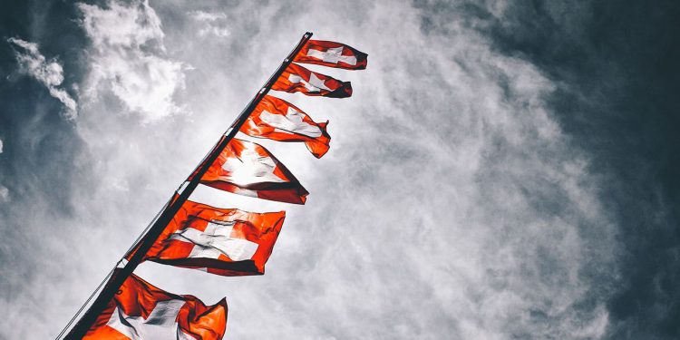 Swiss flag in front of clouds